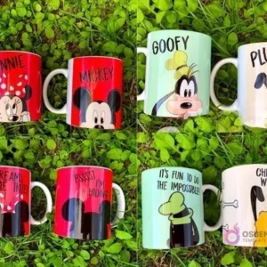 Cuatro tazas sublimadas con personajes Disney (Minnie, Mickey, Goofy, Pluto) sobre césped verde, mostrando anverso y reverso