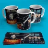 Tres tazas blancas con diseños de rockeros y la banda U2, con gráficos de guitarra y la frase 'Aquí Toma Rockero', sobre fondo azul. Incluye tiras de diseño plano.