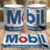 Dos tazas blancas de sublimación con diseño retro grunge del logo de Mobil y dos plantillas planas del mismo diseño sobre una mesa de madera.